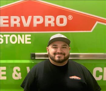 SERVPRO employee in front of green truck