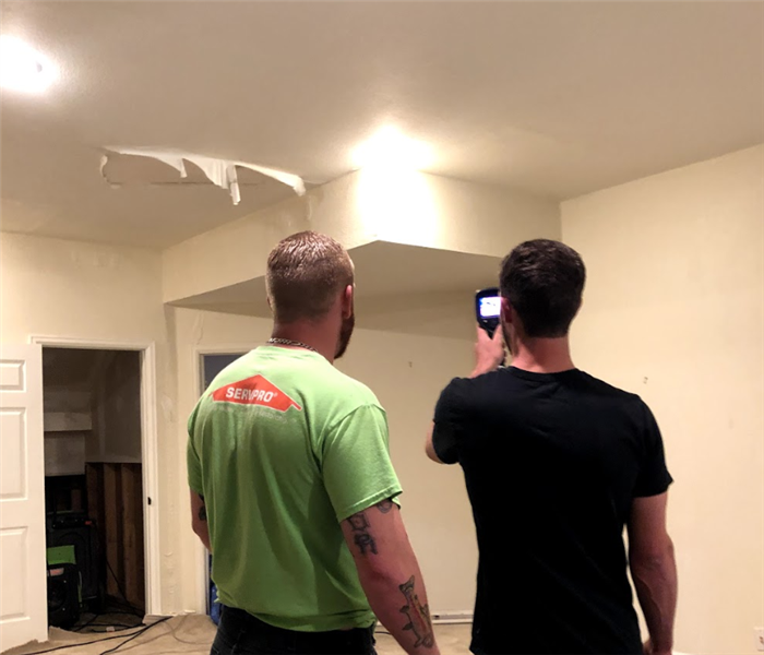 a SERVPRO worker holding a thermal imaging camera in a house