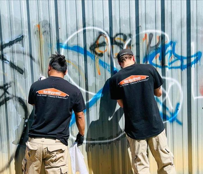 Employees cleaning up graffiti damage. 